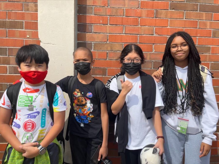 6th graders Justin Wang (left) and Lathan Parker stand with their sisters, Jenny Wang and Laela Parker.